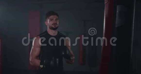 运动的年轻人在进行激烈的艰苦训练他拳击激烈的一个拳击袋视频的预览图