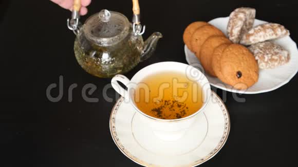 茶杯茶壶和黑背景饼干茶会视频的预览图