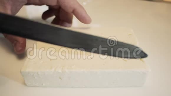 男性用刀子在长片上的玻璃上切割奶酪寿司的奶酪视频的预览图