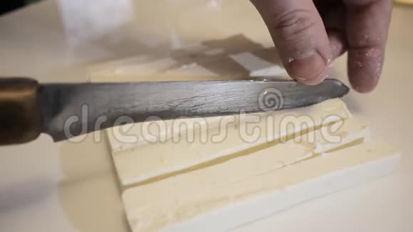 男性用刀子在长片上的玻璃上切割奶酪沙拉的奶酪视频的预览图