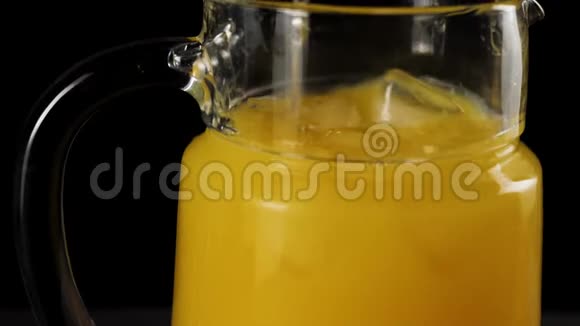 调酒师用勺子在黑色背景下用一个缓慢运动的解码器搅拌新鲜橙汁冰块视频的预览图