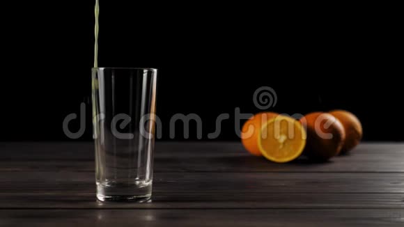 一张木桌上摆满了鲜橙汁用透明玻璃倒入用软焦点的美味橙子装饰视频的预览图