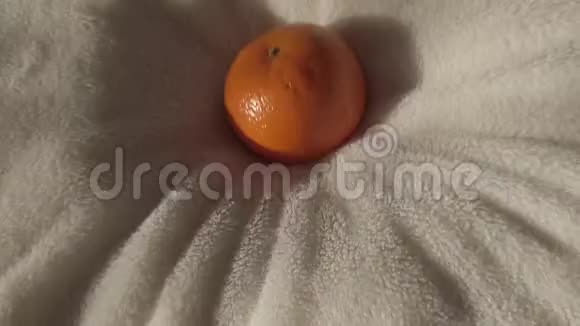 橘子慢慢地落在白色毛巾背景上视频的预览图
