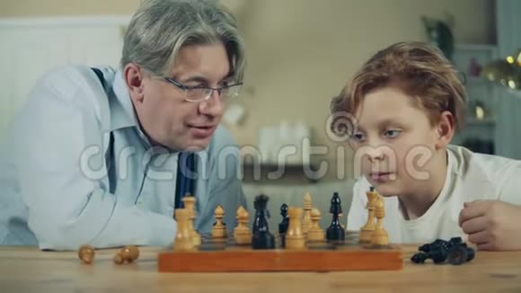 老人和他的孙子密切注视着棋子视频的预览图