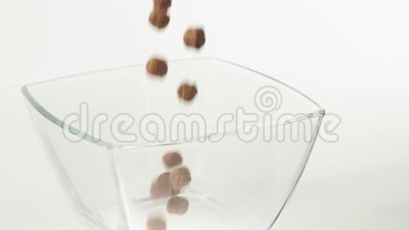 新鲜健康食品巧克力麦片球落在白色背景的透明方形碗里健康的概念视频的预览图