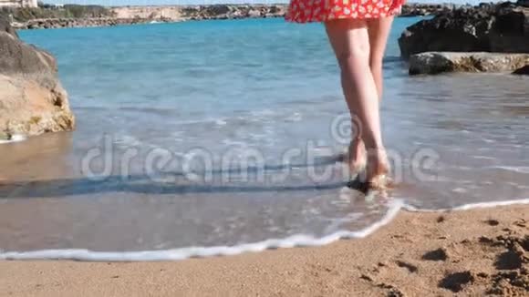 年轻的白种人女孩来到海边的水中穿着红色短裙在海滨散步的布鲁内特女孩阿塔拉克视频的预览图