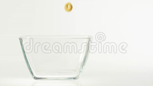 新鲜健康食品黄色的谷物落在白色背景上透明的方形碗里健康早餐的概念视频的预览图