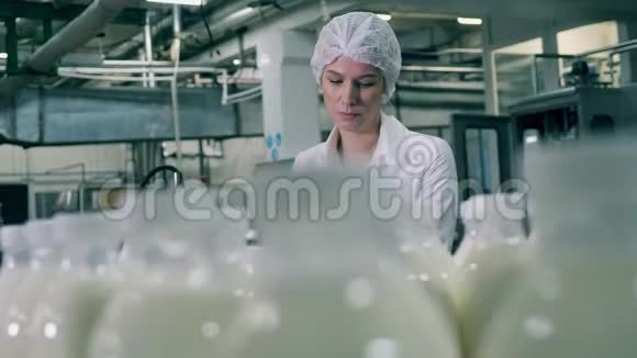 女员工正在食品厂检查乳制品生产过程视频的预览图