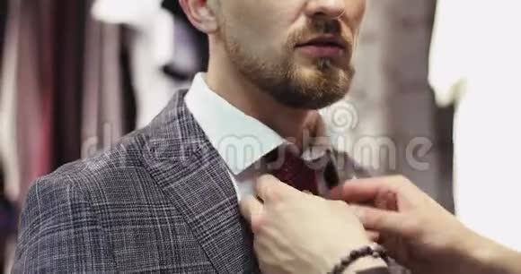 留着胡子的帅哥在裁缝店里试穿一套现代西装视频的预览图