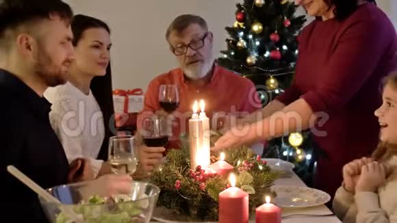 家庭圣诞晚餐妇女在节日庆祝活动中供应美味的火鸡人们坐在餐桌旁享受视频的预览图