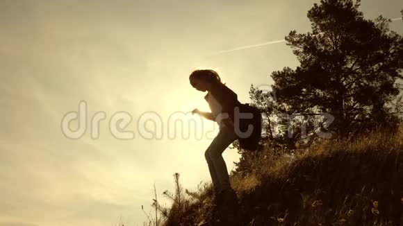 徒步女孩向胜利前进女旅行者从山上下来在日落时旅行的青少年游客A视频的预览图
