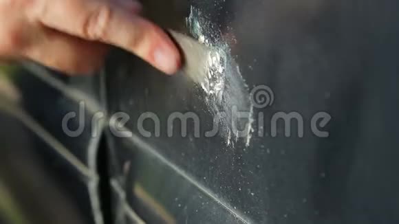 一个人用刮痕清理汽车上的铁锈视频的预览图