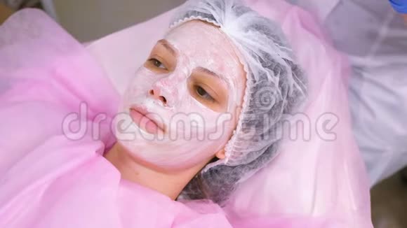 美容师把一张塑料薄膜贴在保湿面膜上面贴在女人脸上视频的预览图