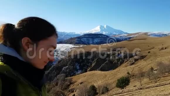 快乐的黑发女孩旅行者在美丽明亮的山脉背景下自拍埃布勒斯在后台视频的预览图