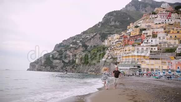 视频情侣在海滩浪漫牵着手跑嬉戏年轻一对情侣在休闲中享受浪漫视频的预览图