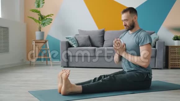 灵活的男子伸展身体在坐姿做向前弯曲腿视频的预览图