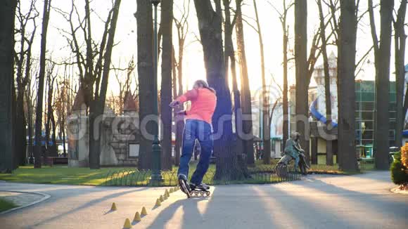 训练一个专业的滚轮在城市的中央公园熟练地溜冰并进行复杂的转弯视频的预览图
