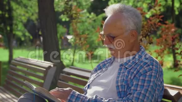 老人独自在公园看书与自己交谈视频的预览图