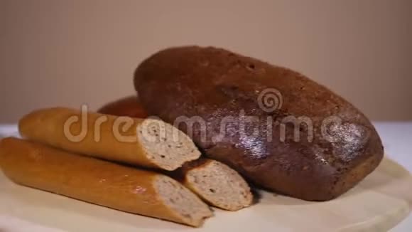 在旋转的盘子里放着美味的新鲜烤白和棕色面包视频的预览图