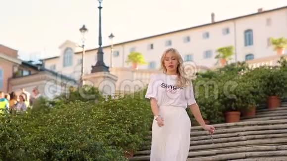 日落时分美丽的白衣少女独自走下罗马市中心的楼梯一天的散步视频的预览图