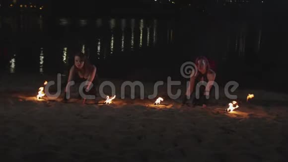 一群女性在沙滩上举起点燃的火炬视频的预览图