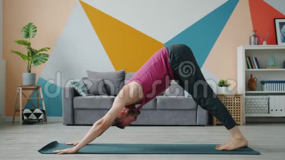 一个留胡子的人在家里做瑜伽在公寓里独自工作视频的预览图