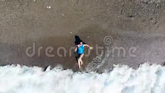 一位女士躺在海边的海浪下旅游度假度假的理念视频的预览图