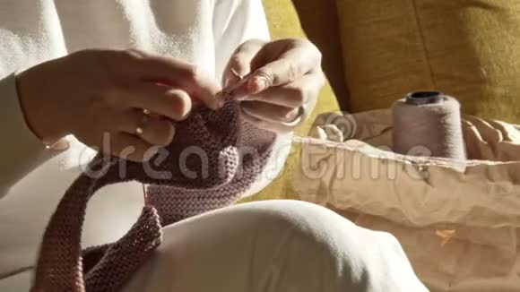 女人用手在沙发上编织针视频的预览图