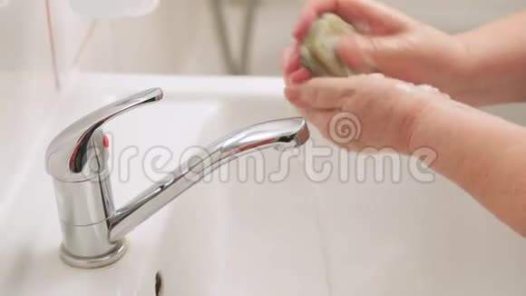 老年妇女在自来水龙头下用肥皂洗手可作为ncov期间的卫生图示概念视频的预览图