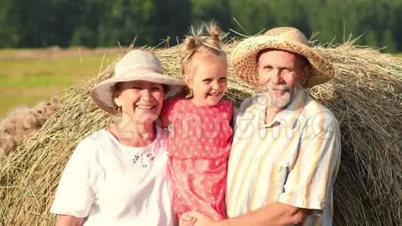 快乐的祖父母和小孙女在草地上视频的预览图