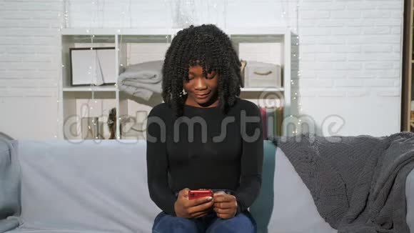 非裔美国女孩看着智能手机变得快乐起来视频的预览图