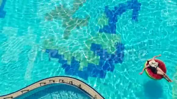 女人漂浮在一个大游泳池里的橡胶圈上视频的预览图