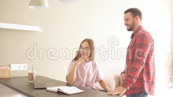 年轻夫妇带着迷人的微笑看着笔记本电脑表现出积极的情绪视频的预览图