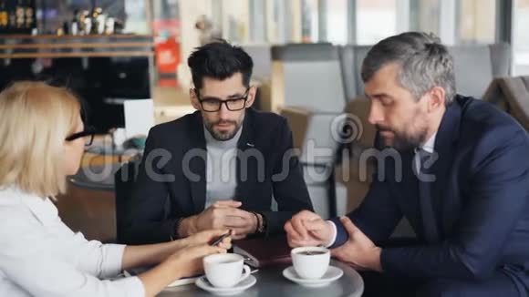 英俊的企业家在现代咖啡馆与成功的商人交谈视频的预览图
