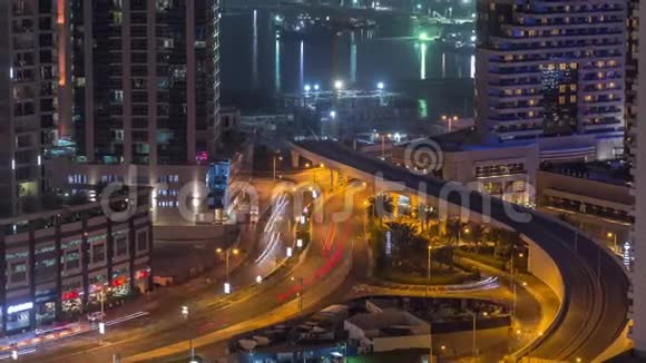 鸟瞰迪拜码头摩天大楼与建筑工地和棕榈朱美拉岛背景夜间时间推移视频的预览图