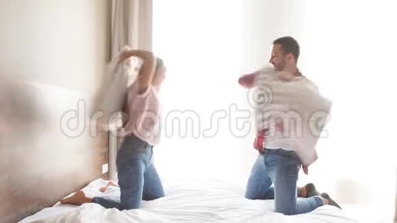 喜出望外的恋人们在家里玩在卧室里玩兴高采烈地用枕头打架笑容满面视频的预览图