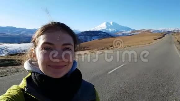 女孩旅行者在登上埃尔布鲁斯的路上自拍光明的俄罗斯之旅秋天的风景旅行者的姿势视频的预览图