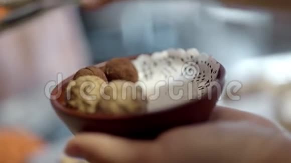 女人手拿着一个巧克力球放进盘子里视频的预览图