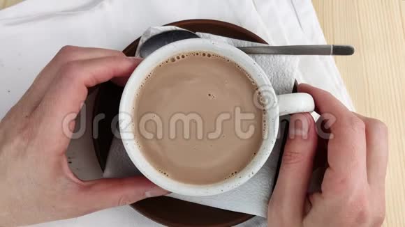 可可饮料被条纹移动两只手拿着杯子制作热巧克力的棕色天然成分特写木制视频的预览图