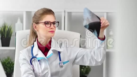 女性医务工作者戴眼镜并统一检查病人x光介质视频的预览图