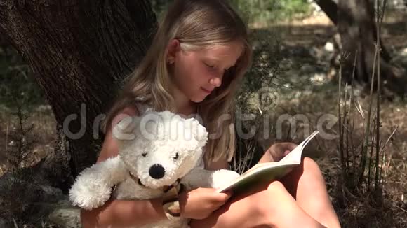 由大树女学生阅读的儿童读物享受在Nature4K学习的户外儿童视频的预览图