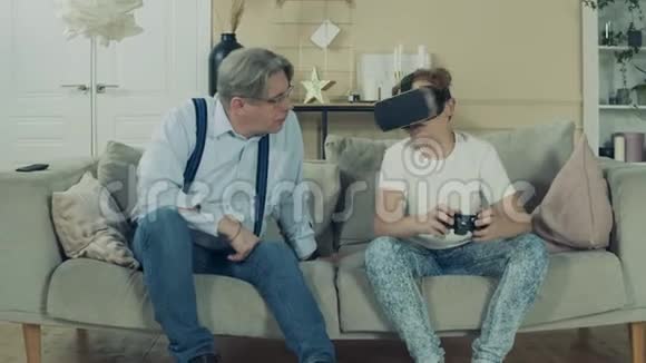 老人正在观察他的孙子玩虚拟现实游戏视频的预览图
