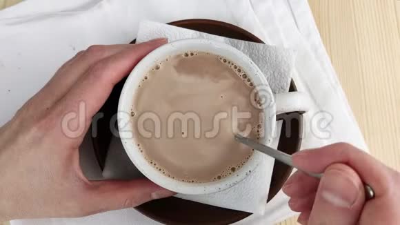 杯中可可饮料用勺子搅拌成圈饮料以条纹移动制作热巧克力的棕色天然成分视频的预览图