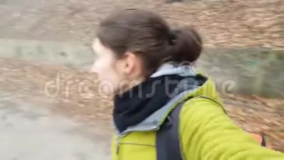一个受惊的年轻女孩走在一条被遗弃的老路上在一片薄雾的森林里博客正在播放危险的散步视频的预览图