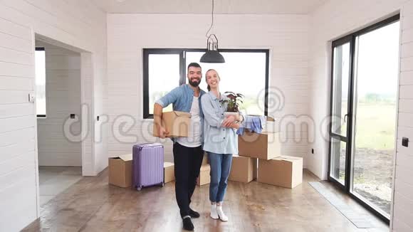 漂亮的欧洲夫妇站在一间新房子的宽敞房间里视频的预览图