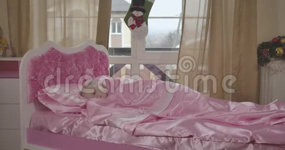 可爱的白人女孩睡在粉红色的床上的肖像安静的孩子早上在她的房间里休息童年视频的预览图