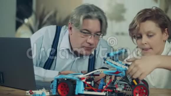 一位老人和他的孙子完成了一台玩具机视频的预览图