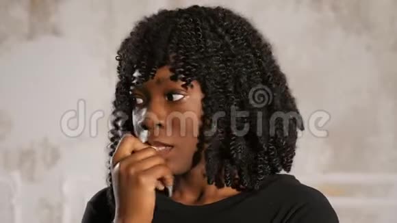 紧张的卷发女士用手指在嘴唇上特写视频的预览图
