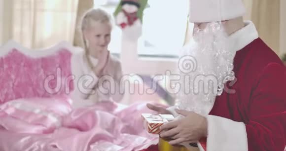 白种人模糊的孩子在背景上搓手圣诞老人送给她圣诞礼物女孩拥抱成人视频的预览图