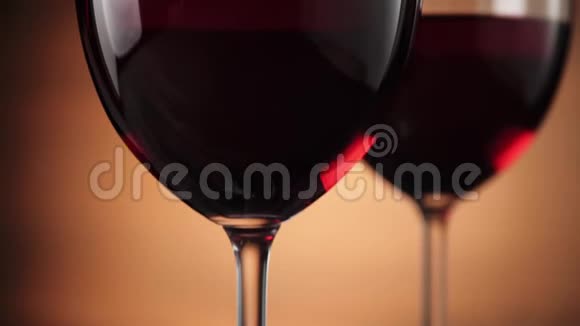 豪华红酒美味的葡萄酒由两个酒杯中的美味红葡萄在棕色背景下制成视频的预览图